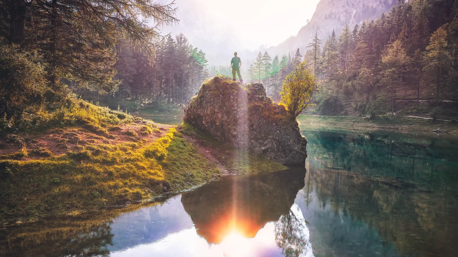 person standing on rock with sunshine in background