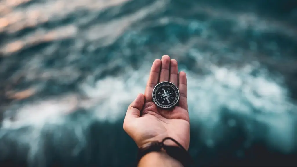 Hold handing a compass over water