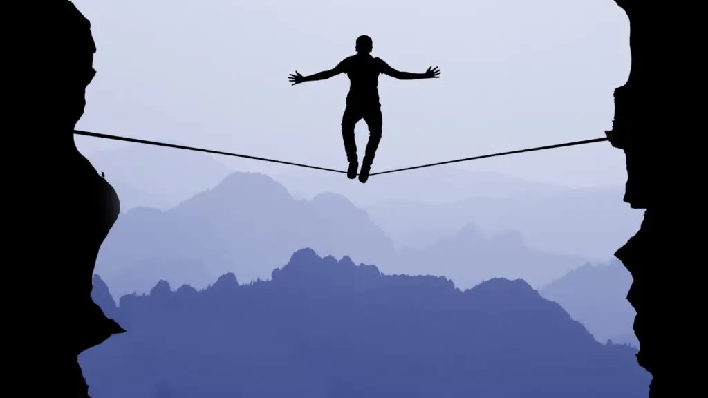Person tightrope walking across canyon
