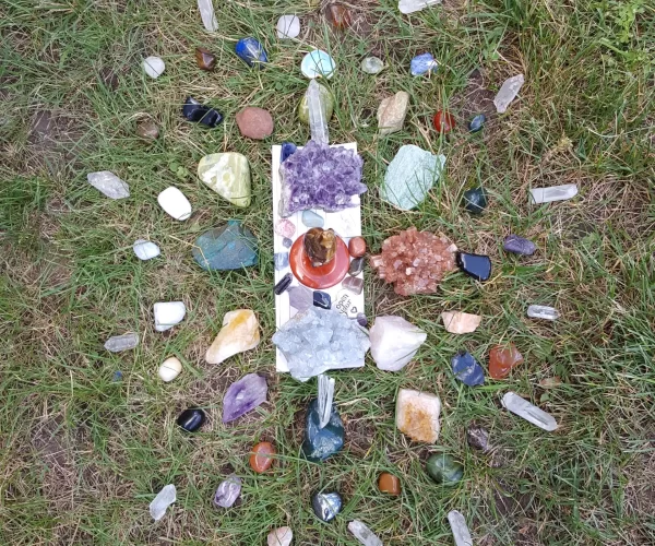 Image of stones and crystals in the shape of an alter on grass.